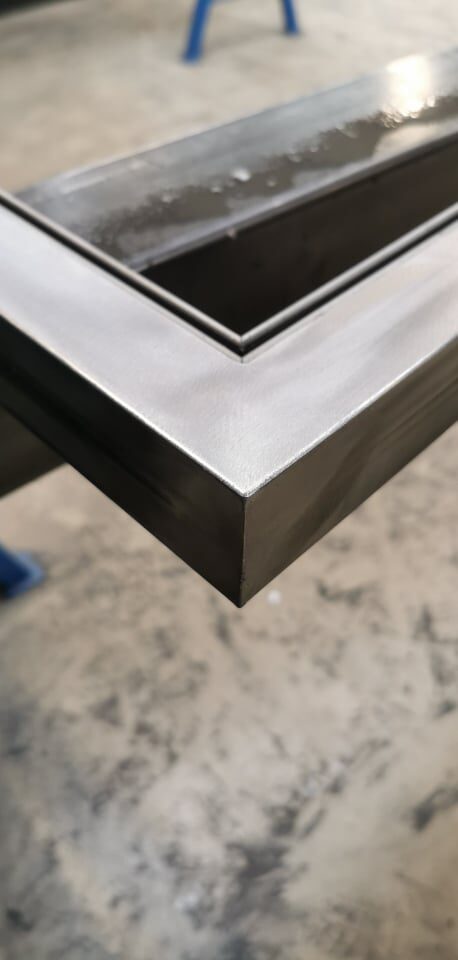 Détail d'angle métallique poncé et fini, travail d'atelier